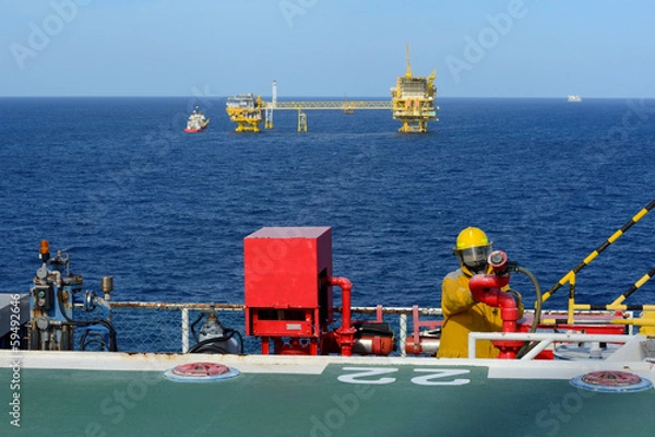 Fototapeta fireman is guarding for offshore helicopter before start up engi