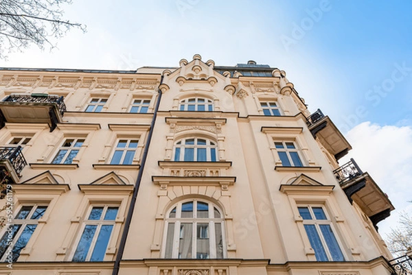 Fototapeta Facade of old tenement house, residential building with balconies. Low angle view of renovated block of flats
