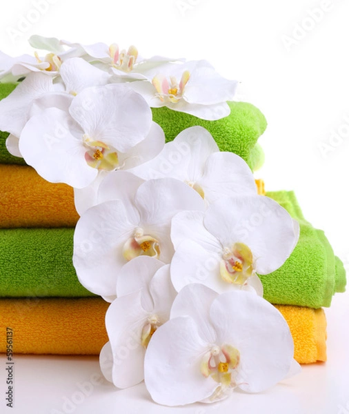 Fototapeta Colorful towels and orchid flowers, isolated on white