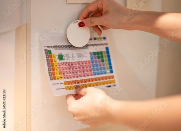 Fototapeta Female hand attaching element paper to the magnetic board for remind the important notice.