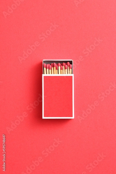 Fototapeta red matchstick in red matchbox on red paper background with copy space