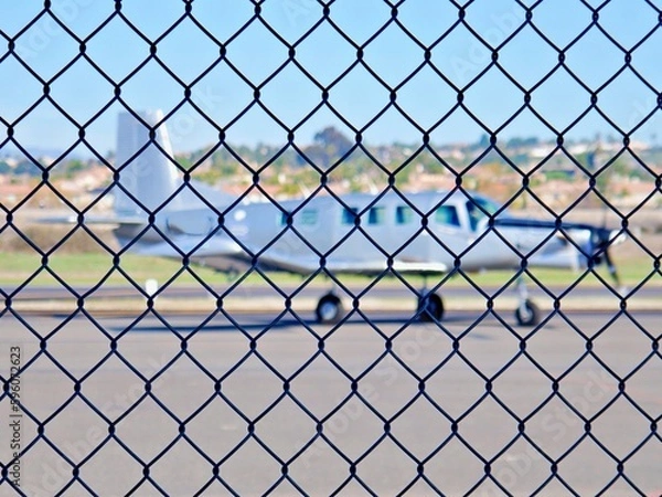 Obraz Flugzeug hinter Maschendrahtzaun