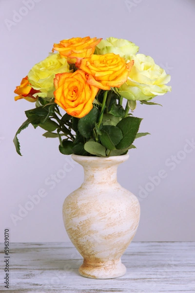 Fototapeta Beautiful bouquet of roses in vase on table on gray background