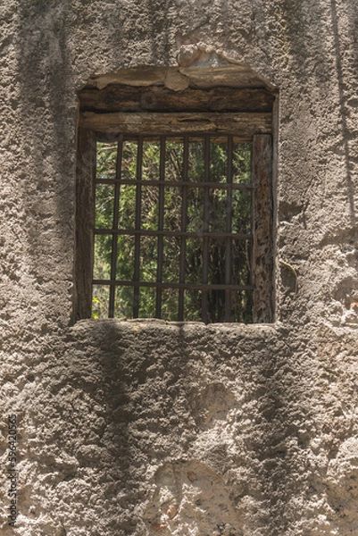 Fototapeta Window of an old house in a wall of adobes and quarry.