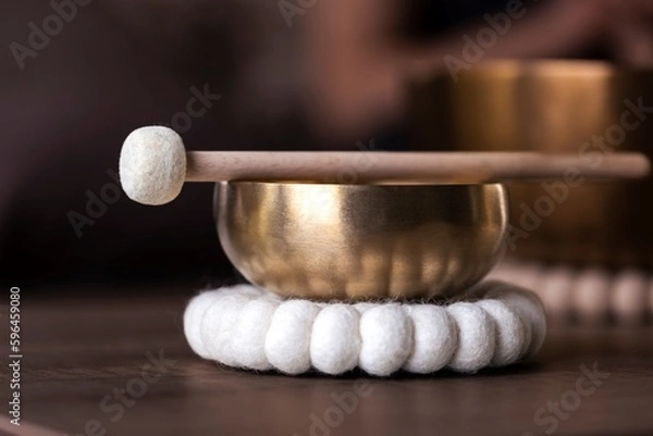Fototapeta A portrait of a tibetan singing bowl or himalayan bowl, with a mallet lying on top of it to make a relaxing sound. The object is used for therapy to relieve stress and relaxation, meditation.