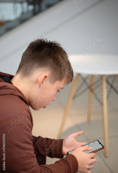Fototapeta Teenager with a smartphone. In the hands of a touch phone. WiFi. Correspondence in messengers. Internet.