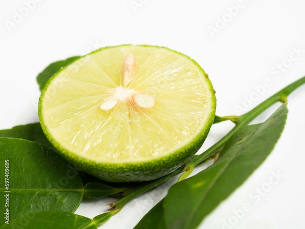 Fototapeta Picture of green citrus with leafs on a white isolated background