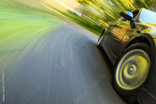 Obraz Front side view of luxury sedan in turn with blurred motion.