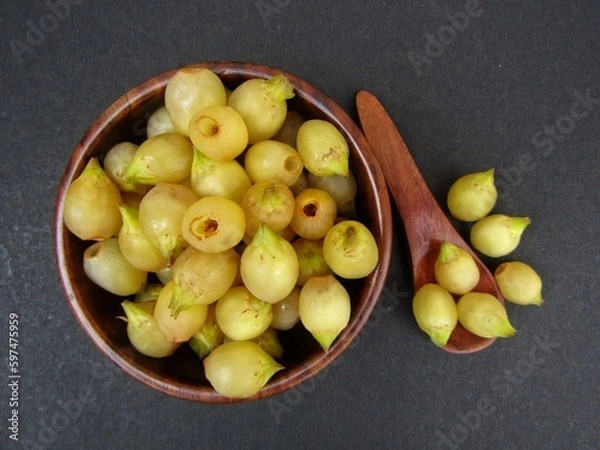 Obraz Madhuca longifolia or Mahua in a wooden bowl on black background  top view 