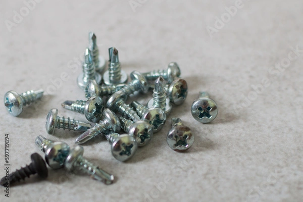 Fototapeta Tools for building - many little tapping screws, on the grey background
