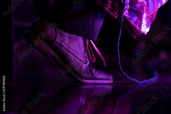 Fototapeta A man on stage, in old shoes, at a musical show, audio cable on one side.