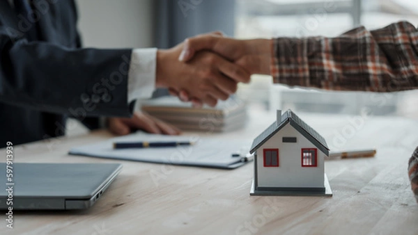 Fototapeta Shaking hands, Real estate agent with client considering buying a new home To pay a bribe to sign to approve the purchase, bribery concept.