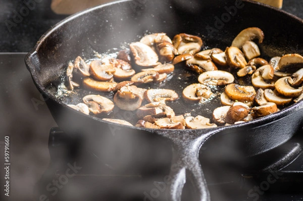 Obraz Sauteing sliced mushrooms in a skillet