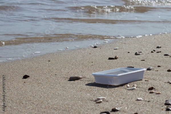 Obraz Spilled garbage on the beach of the big city. Plastic. Dirty sea. Environmental pollution. Ecological problem.