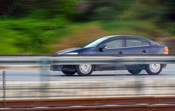 Fototapeta Car driving fast motion on highway side view