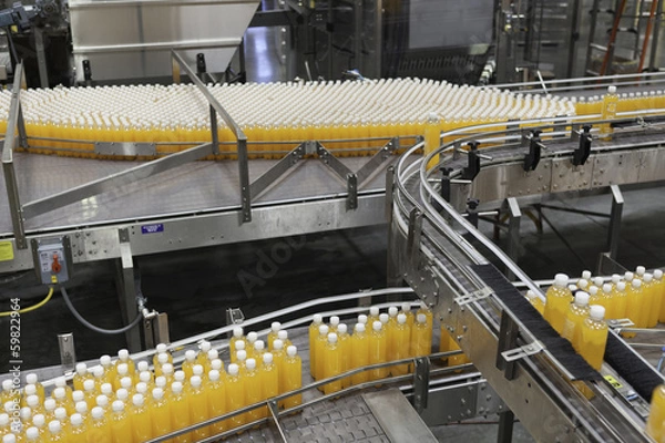 Fototapeta Packed bottles moving on conveyor belt