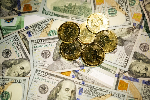 Obraz Gold Bitcoin on hundred dollars bills. Close-up