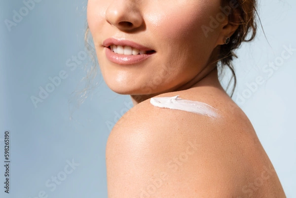 Fototapeta Woman with   cream on  shoulder, enjoy soft and shiny skin.