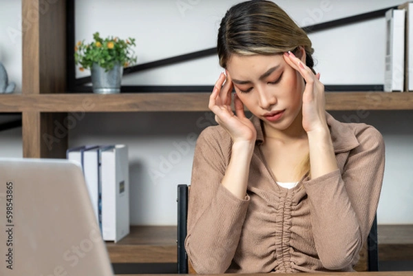 Fototapeta Young woman working on laptop computer at home