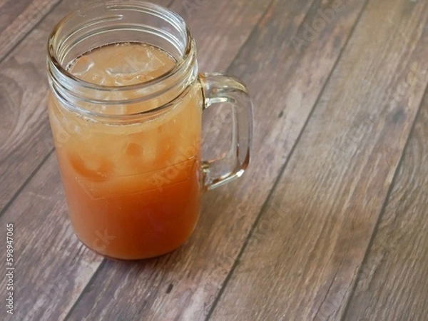 Fototapeta jar of grapefruit juice in a kilner glass on a wooden table