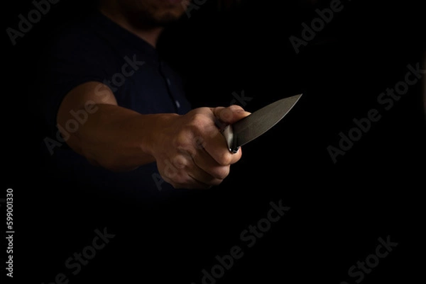 Obraz Adult Man Holding Sharp Knife in the Shadow. Concept Picture of Murderer, Killer, Assasin, Robber or Theft