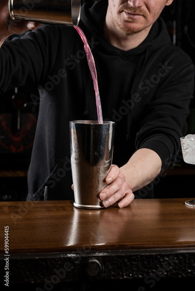 Fototapeta Bartender mixes egg white, lemon, dry vermouth and gin to prepare the Clover club cocktail. Barman prepares classical Clover club alcoholic cocktail at the bar.