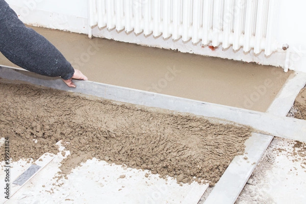 Fototapeta mason leveling the cement screed