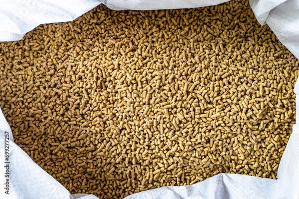 Fototapeta Feed for livestock. Rich nutritional Pellet animal feed on white background. A bag. Large granules crumbled. A white bag of granulated chicken feed isolated on white background