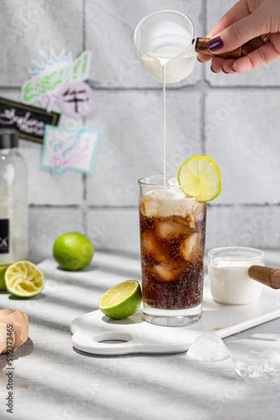 Fototapeta Prepairing authentic dirty soda cocktail with lime juice and cream in the kitchen table