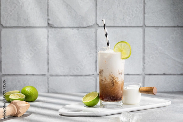 Fototapeta Trendy authentic dirty soda cocktail with cola, lime juice and cream in the kitchen table