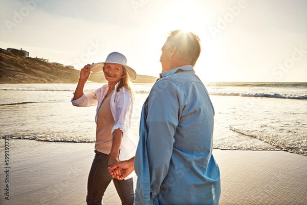 Fototapeta Dont go a day without making your spouse feel special. a mature couple spending the day at the beach.