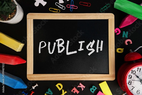 Fototapeta Wooden board with Publish text on a background of various colorful subjects