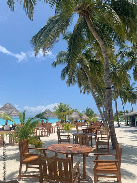 Obraz A day in the Maldives, an open restaurant among palm trees, almost without people, next to the beach on the Indian Ocean