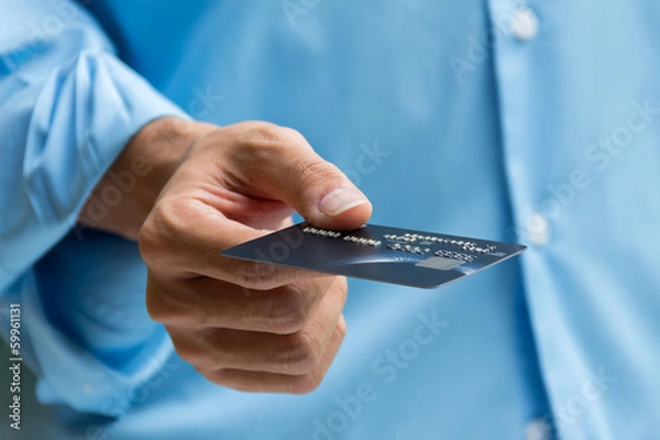 Obraz Closeup of hand holding and giving credit card for payment