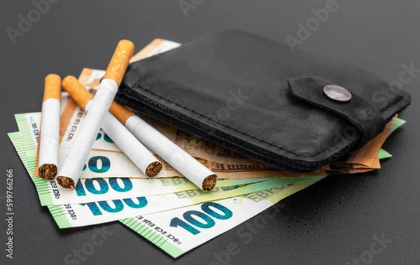 Fototapeta Cigarettes with wallet and euro bills on black background.