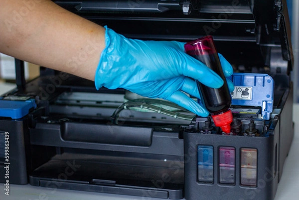 Fototapeta Technicians Refill ink cartridges, printer Inkjet colors.Printer Repairs and Maintenance inkjet or Laser printers concept ,selective focus