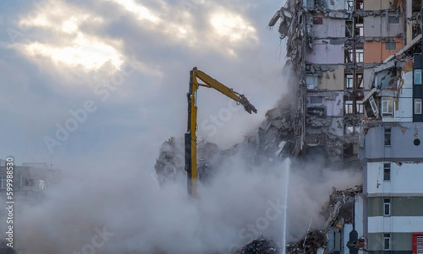 Obraz Controlled demolition of building construction. Demolition of an earthquake-resistant building with a bulldozer