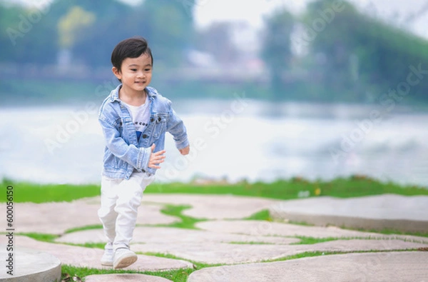 Fototapeta Asian happy kid running the summer park.
