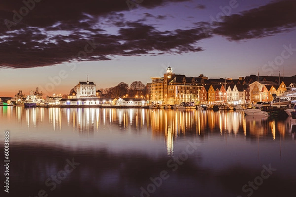 Fototapeta Captivating night view of Bergen's iconic Bryggen marina, adorned with shimmering reflections over the tranquil waters, showcasing the enchanting ambiance of the city's vibrant nightlife, illuminated 