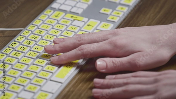 Fototapeta Close-up of a computer keyboard with braille. A blind girl is typing words on the buttons with her hands. Technological device for visually impaired people