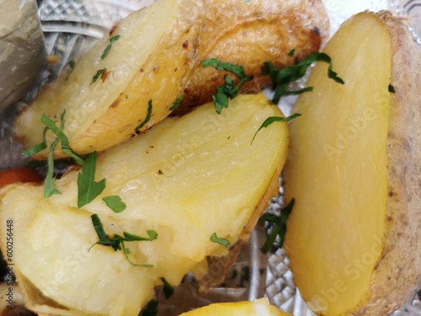Fototapeta Serving of boiled whole young potatoes with butter, sprinkled with fresh chopped dill on the table, top view close-up in selective focus