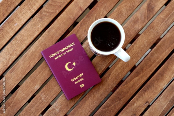 Obraz Turkish passport with coffee cup on wooden table photographed from above
