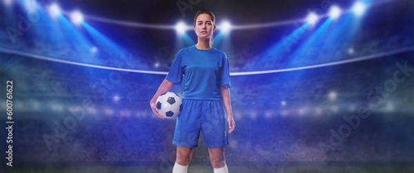Fototapeta  Portrait of young female soccer player with soccer ball standing in a big stadium.