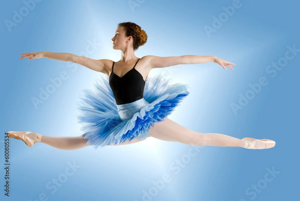 Fototapeta dancer in blue tutu jumpig on a shining blue background