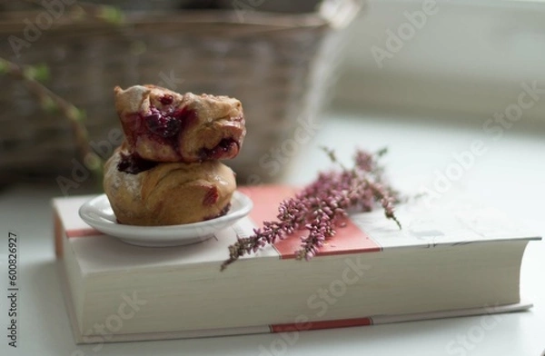 Fototapeta Two berry muffins on a book.