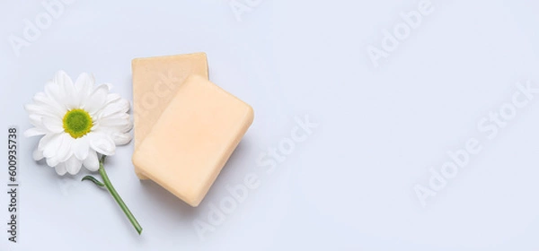 Fototapeta Soap bars and chamomile flowers on light background with space for text
