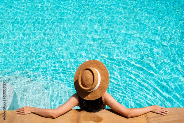 Fototapeta Asian woman in swimwear relaxing in swimming pool during her summer holiday leisure time at luxury resort. Copy space, top view. Summer and vacation concept
