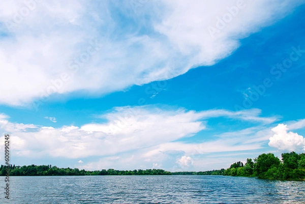 Fototapeta Summer landscape. Lake and blue sky in light white clouds.