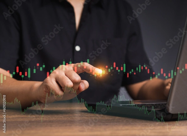 Obraz Stock exchange market analysis. A businessman or trader pointing to a graph stock on a virtual screen