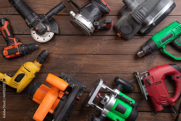 Fototapeta Set of electric tools on the wooden table. Various power tools for renovation and construction